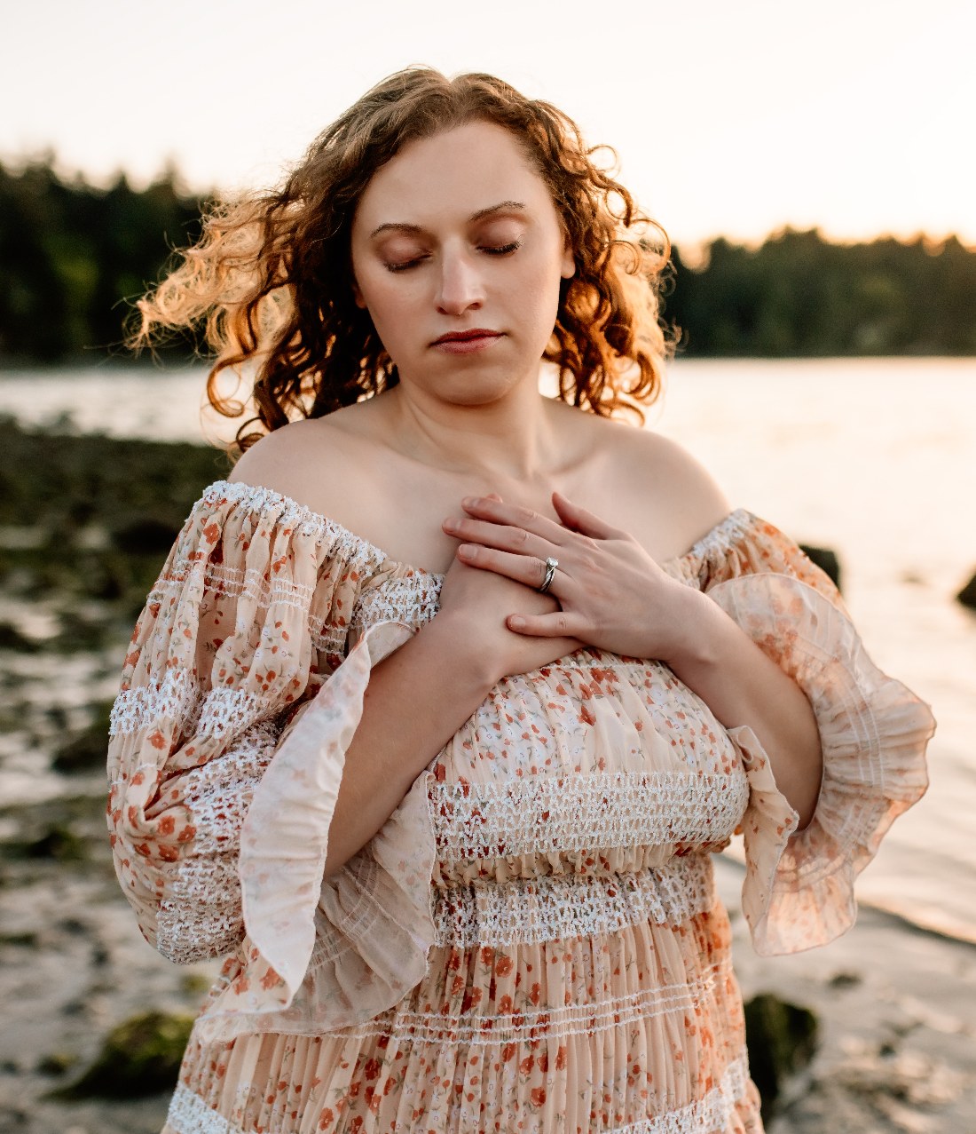 Kayla Moore, Keeper of Walk As Love Temple, hands on heart at golden hour by the water